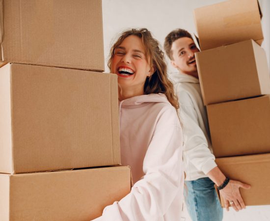 Happy,Young,Family,Couple,Man,And,Woman,Moving,With,Cardboard